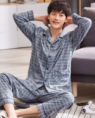 Men's grey flapped collar pajamas with geometric print worn by a man sitting on a rug in a house