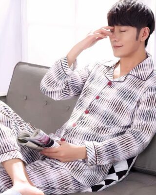 Black striped white pajamas with folded collar for men worn by a man sitting on a sofa in a house