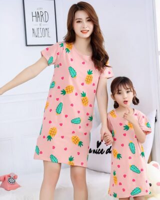 Pink nightgown pajamas with pineapple and pink cactus print complete for mother and daughter worn by a woman and a little girl in a house