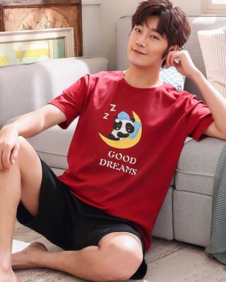 Pajamas in red cotton t-shirt and black shorts with panda pattern very high quality worn by a man sitting on a carpet in a house