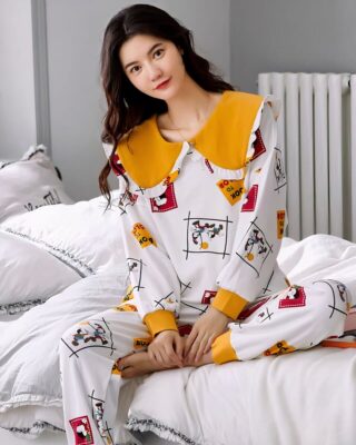 Long sleeve cotton cuffed pajamas for women very high quality worn by a woman sitting on a bed in a house