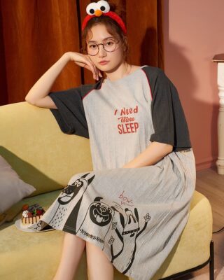 Dog print cotton nightgown pajamas worn by a woman sitting on a sofa in a house