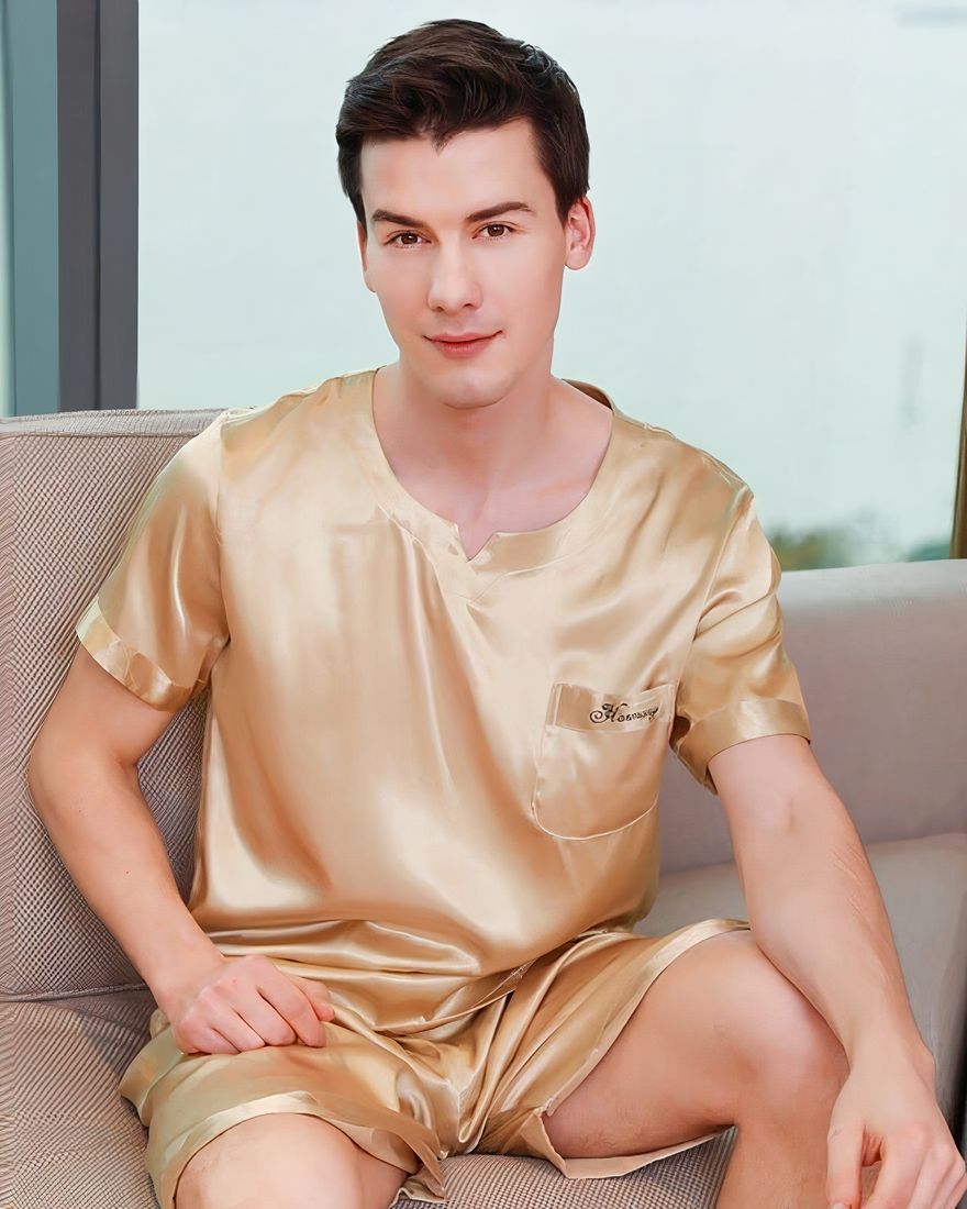Golden satin pajamas for a man sitting on a sofa in a house