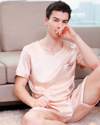 Champagne two-piece pyjamas for men worn by a man in front of a sofa in a house