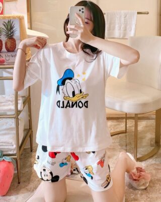 White Donald printed satin summer pajamas worn by a woman in a house