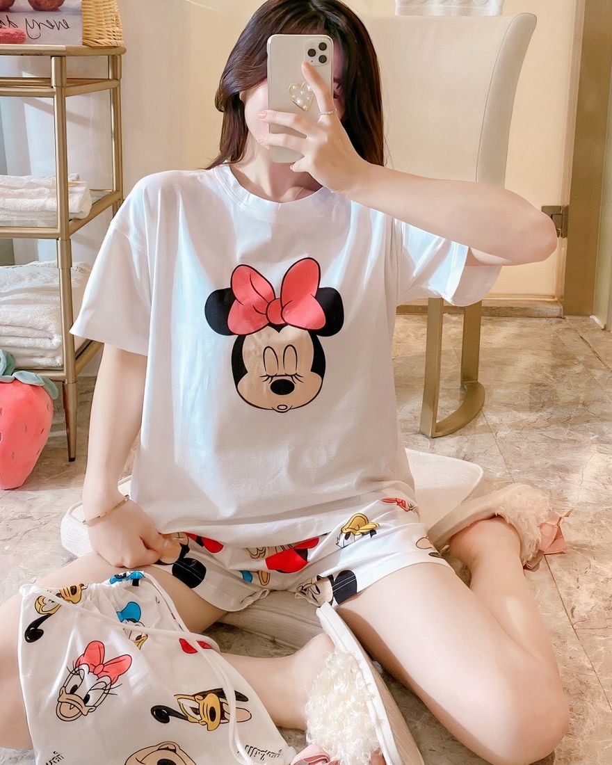 Minnie Mouse printed satin summer pajama set worn by a woman sitting on a bed in a house