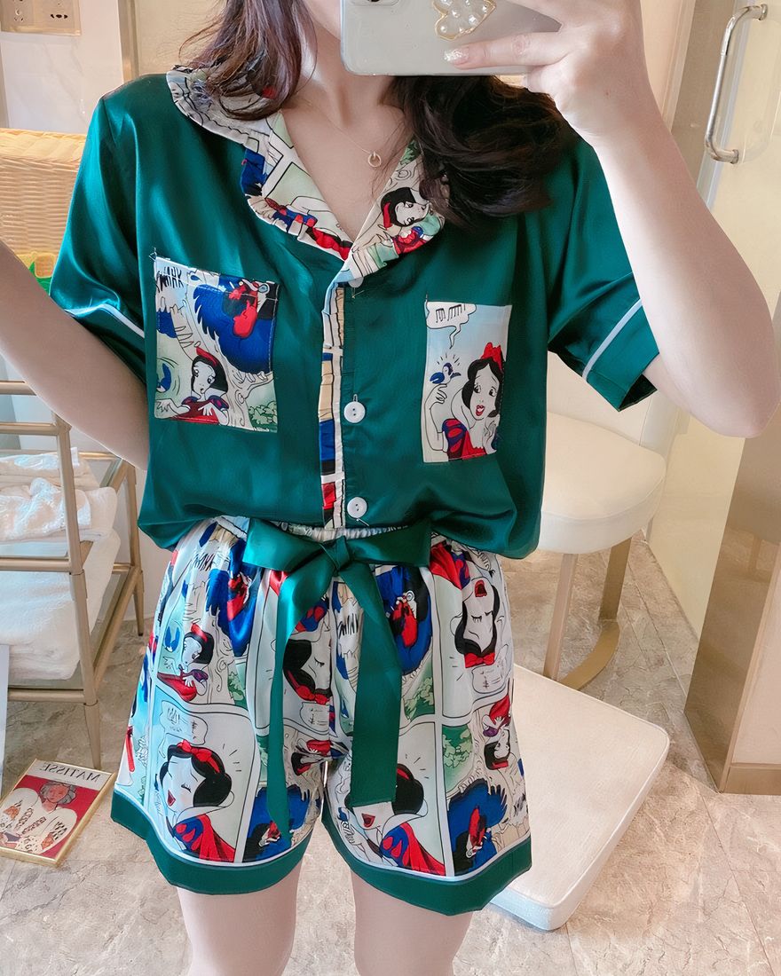 Green silk pajamas with short sleeves Snow White pattern worn by a woman taking a picture in a house