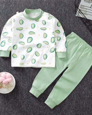 Pajamas for little boy in cotton avocado pattern with plain green pants fashionable on a carpet in a house