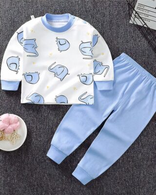 Pajamas for little boy in cotton with elephant pattern and plain blue pants on a carpet in a house