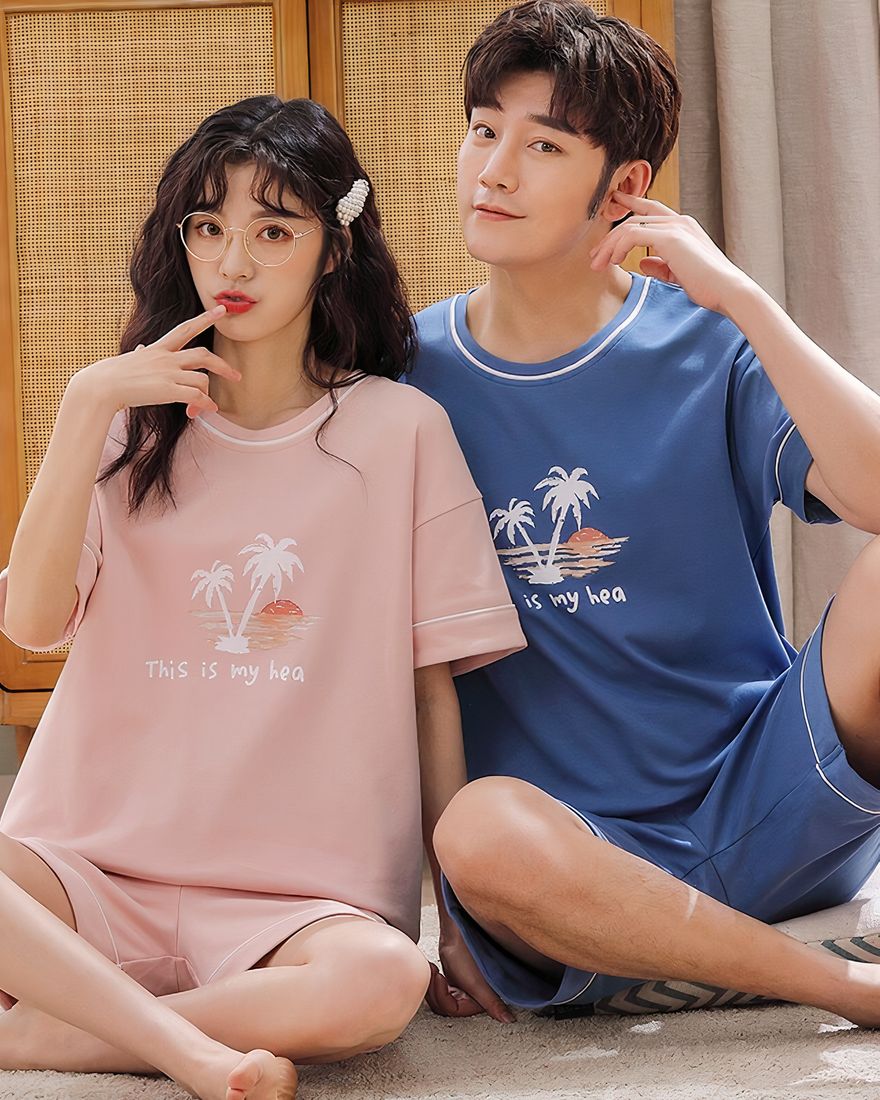 Two-piece cotton pajamas with inscription this is my hea worn by a couple sitting on a carpet in a house