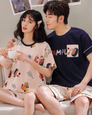 Two-piece cotton pajamas with t-shirt and shorts with cartoon pattern worn by a couple sitting on a sofa in a house