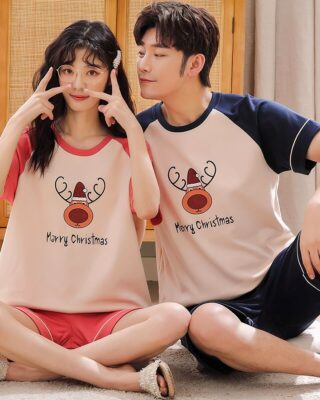 Two-piece cotton pajamas with reindeer shirt and shorts worn by a couple sitting on a carpet in a house