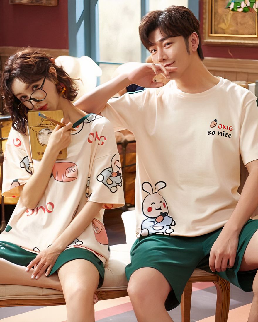 Two-piece cotton pajamas with rabbit pattern worn by a couple sitting on a chair in a house