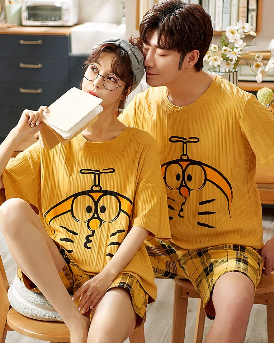 Pyjama t-shirt and mustard yellow shorts with Doraemon motif worn by a couple sitting in a house