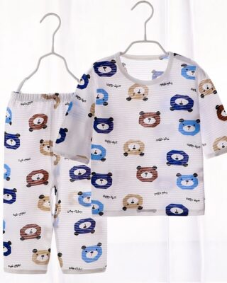 White cotton summer pajamas with bear pattern for child on a belt in a house