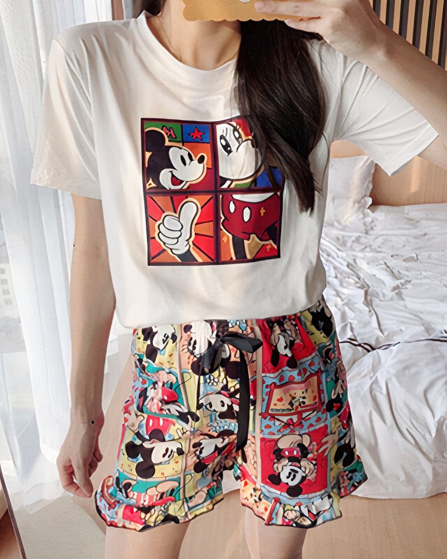Mickey print summer pajamas for woman worn by a woman in front of a bed in a house