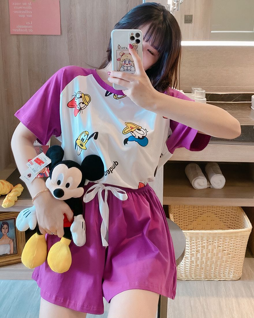 Donald printed t-shirt pajamas with purple and white shorts, worn by a woman wearing a plush