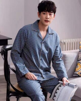 Fashionable cotton pajamas worn by a man sitting on a chair in a house