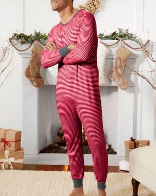 Fashionable men's long-sleeved striped pajamas worn by a man in front of a chair in a house