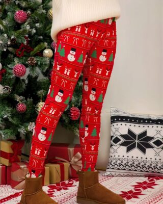 Red christmas print leggings for women worn by a woman in front of a Christmas tree in a house