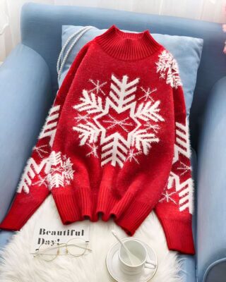 Christmas sweater knitted with white and red snowflake for woman on a chair in a house