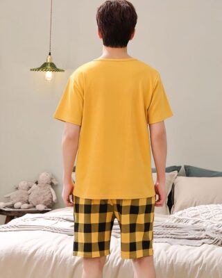 Garfield short sleeve summer pajamas for men yellow worn by a man in front of a bed in a house