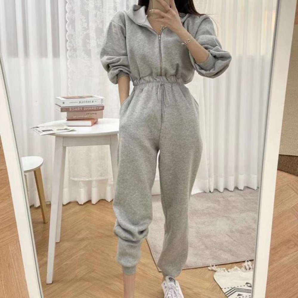 Fashionable women's hooded fleece pajama suit worn by a woman taking a picture