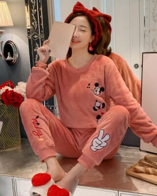 Pink Mickey pajamas for women worn by a woman wearing a red headband in a fashionable house