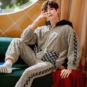Warm hooded pajamas for men worn by a man sitting on a chair in a house