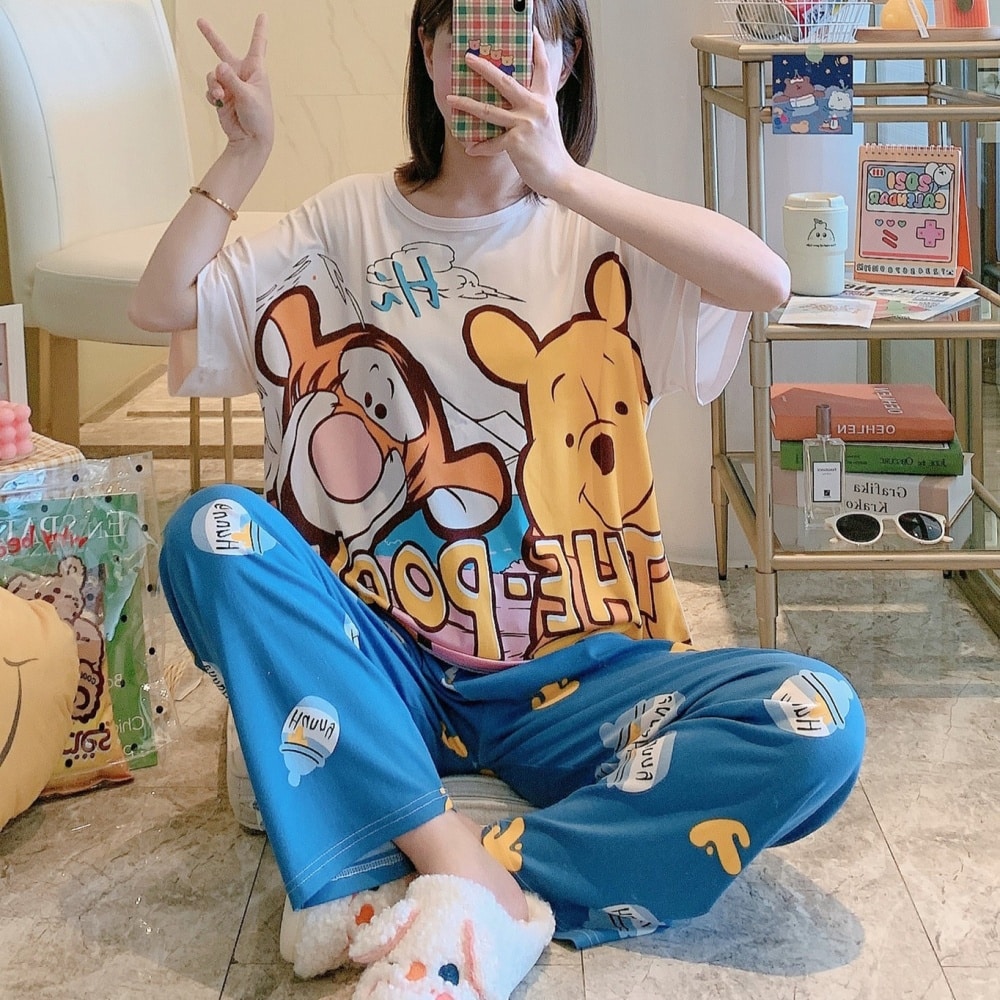 Tigger and Winnie short sleeve pajamas worn by a seated woman taking a picture in front of a mirror