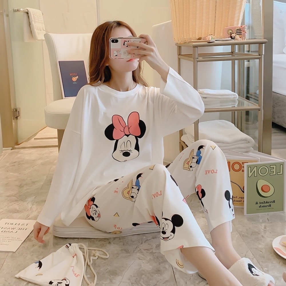 Women's Minnie and friends pajamas worn by a woman sitting in a house