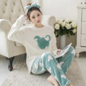 Soft Mickey logo pajamas for women worn by a woman sitting in front of a sofa in a house