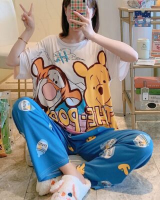 Tigger and Winnie short sleeve pajamas worn by a seated woman taking a picture in front of a mirror