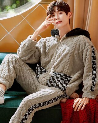 Warm hooded pajamas for men worn by a man sitting on a chair in a house