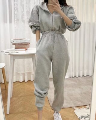 Fashionable women's hooded fleece pajama suit worn by a woman taking a picture