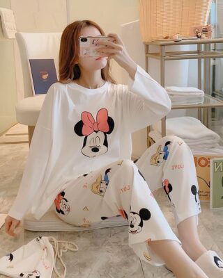 Women's Minnie and friends pajamas worn by a woman sitting in a house