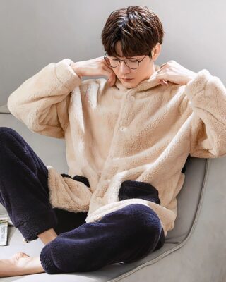 Beige and warm blue fleece pajamas for couple worn by a man sitting on a chair in a house