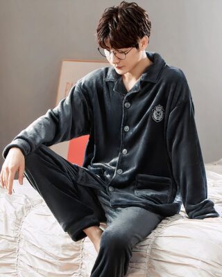 Plain fleece pajamas with collar for couple worn by a man sitting on a bed in a house