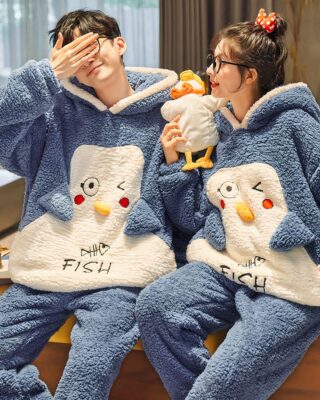 Funny blue and white polar pyjamas for couple worn by a couple in a house