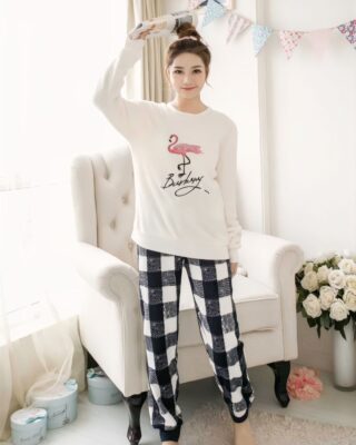 Very comfortable black and white flannel winter pajamas worn by a woman in front of a sofa in a house