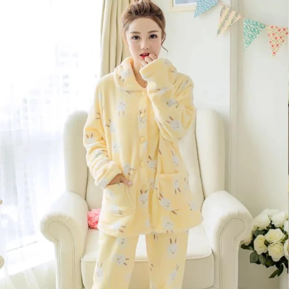 Winter pajamas long sleeves yellow rabbit pattern very comfortable worn by a woman in front of a chair in a house