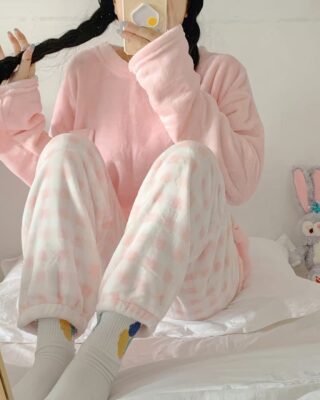 Women's soft winter pajamas candy color and pink and white striped pants worn by a woman taking a fashionable picture