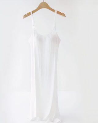 White pregnancy and nursing nightgown on a wooden hanger on a white background