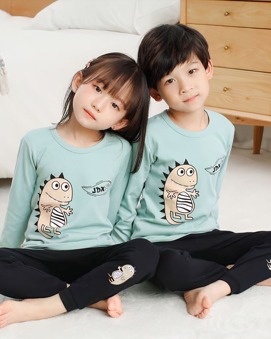 Spring pajamas with light blue sweater and black pants for children with two children wearing the pajamas and a background a room