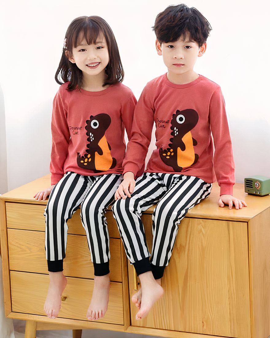 Spring pajamas with pink sweater and black striped white pants for children with two children wearing the pajamas and who are on the furniture