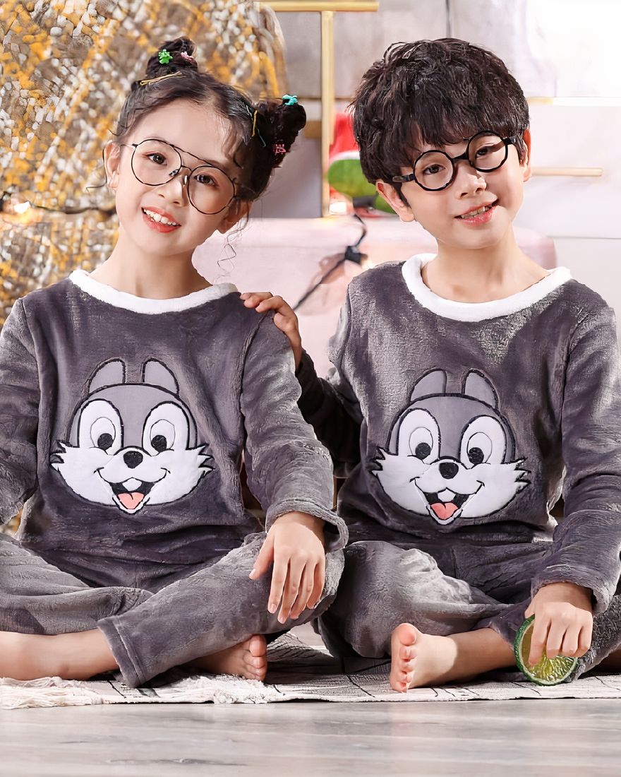 Panpan rabbit flannel pajamas for children worn by a little boy and a little girl sitting on a carpet in front of a night table in a house