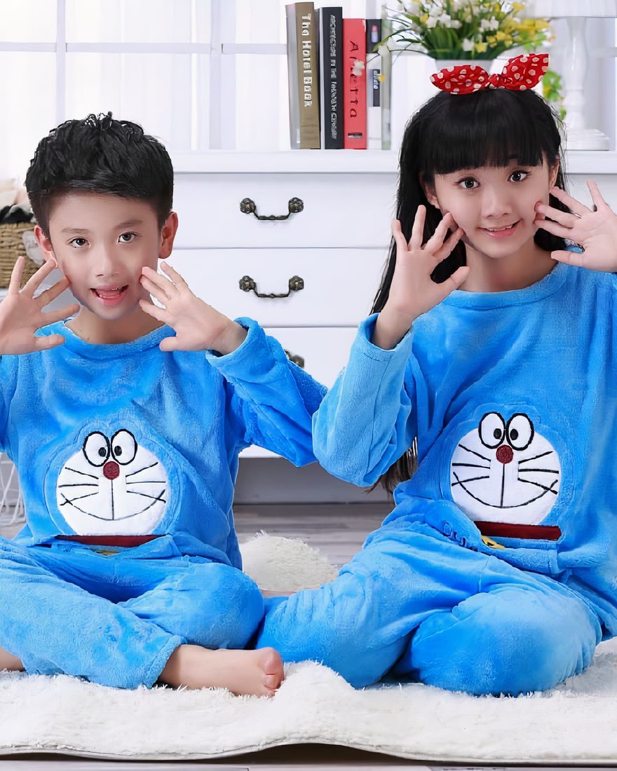 Blue long sleeve flannel pajamas with Doraemon print for child sitting on a carpet in a house