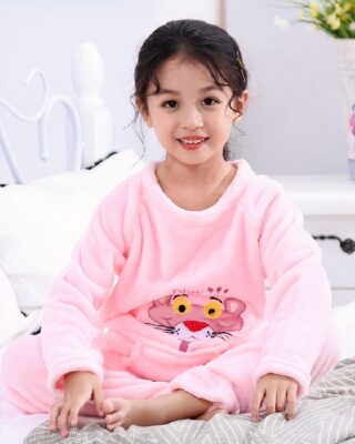 Flannel pajamas with Pink Panther print for girl worn by a little girl on a bed in a house