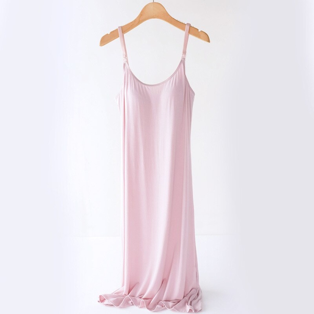 Pink pregnancy and nursing nightgown on a wooden hanger, on a white background