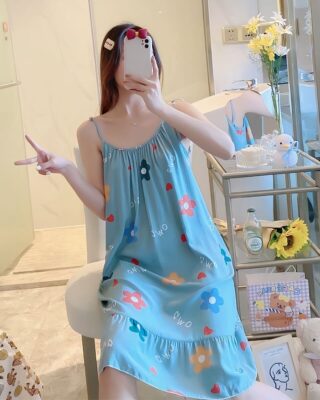 Blue sleeveless cotton nightgown pajamas for summer worn by a woman sitting on a chair in a house